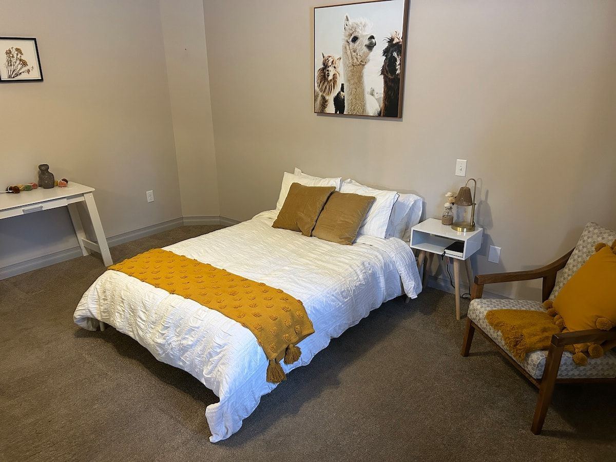 Studio bedroom with white bedding and mustard throw